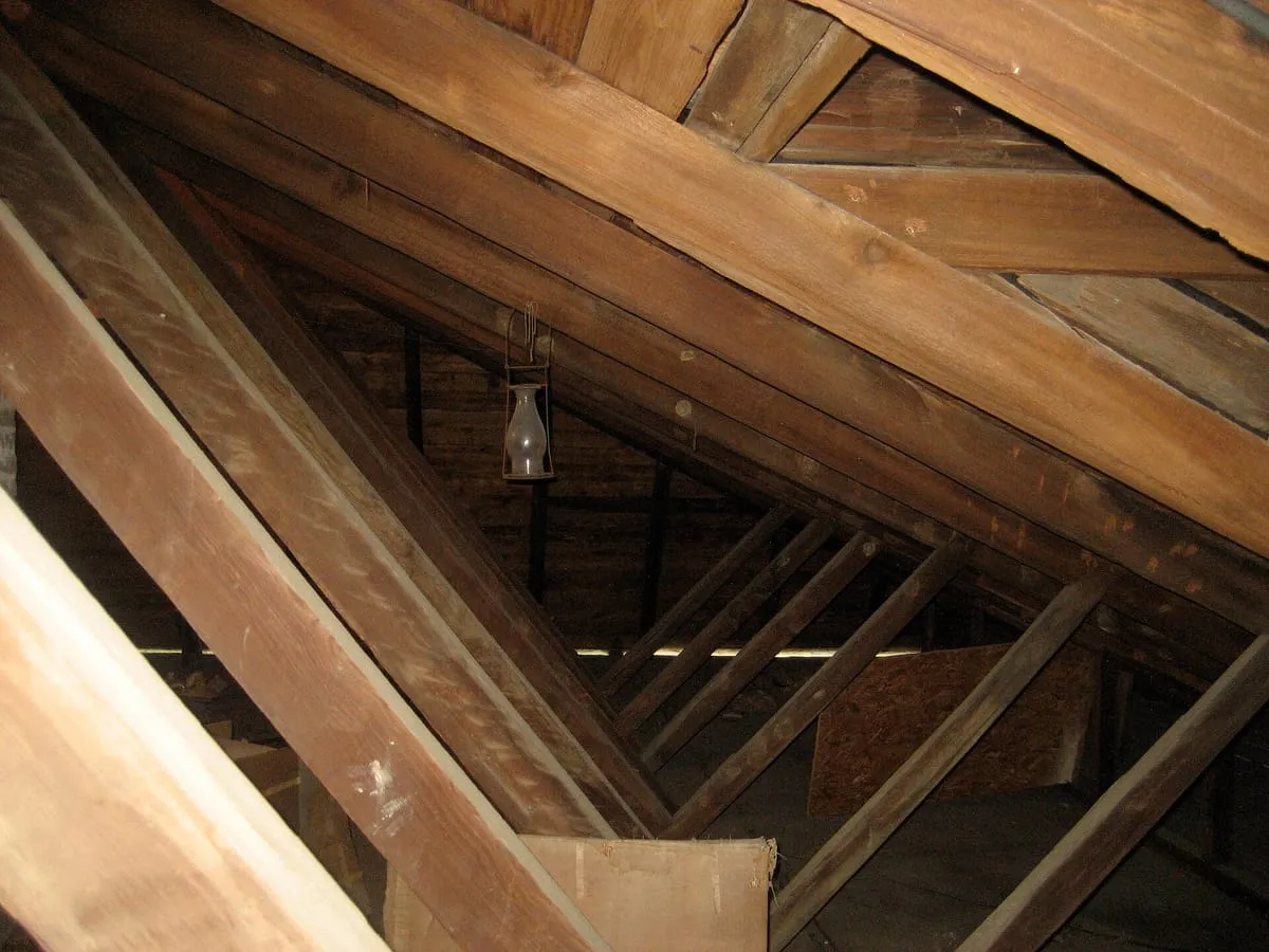 Old wooden rafters and board roof decking seen from inside an attic