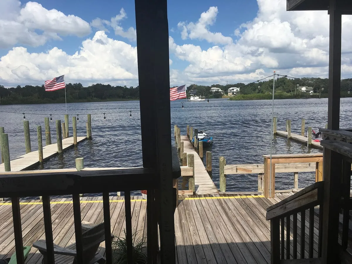 Wooden dock and pilings on the Alafia River near Gibsonton, with houses on the far bank