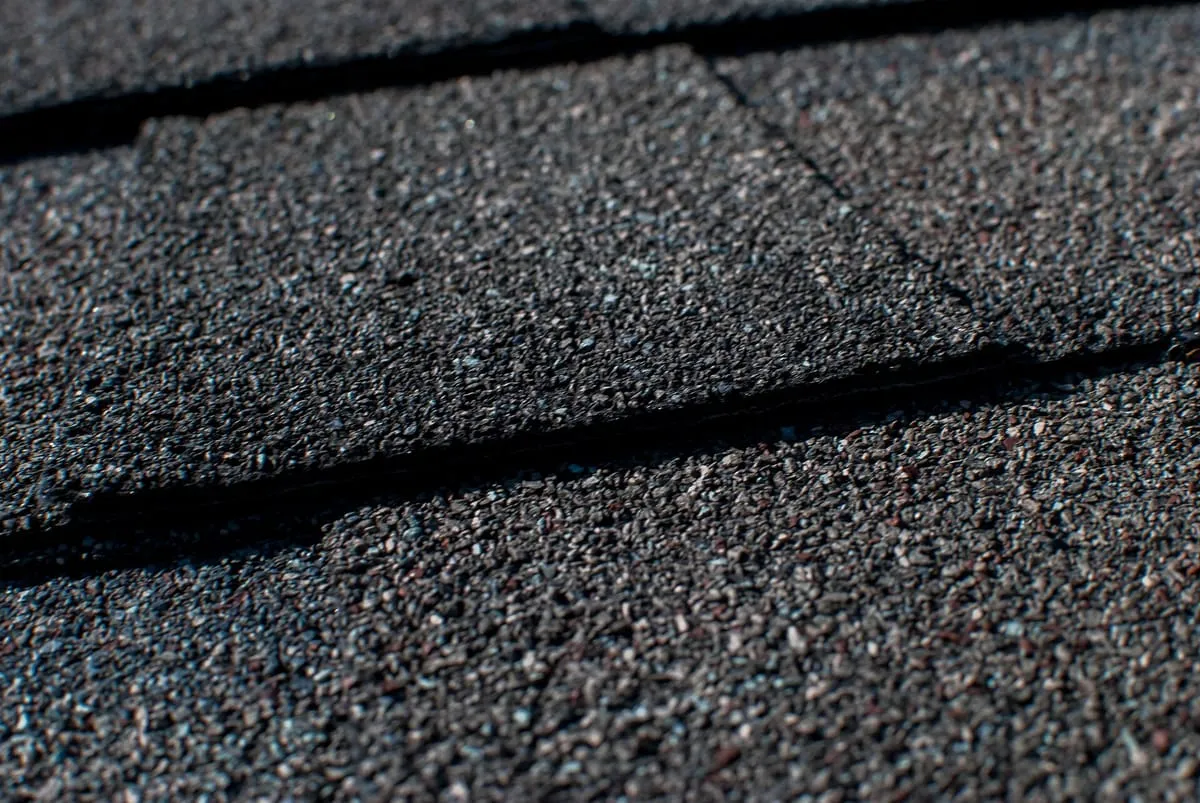 Close-up of dark asphalt shingles covered in fine mineral granules