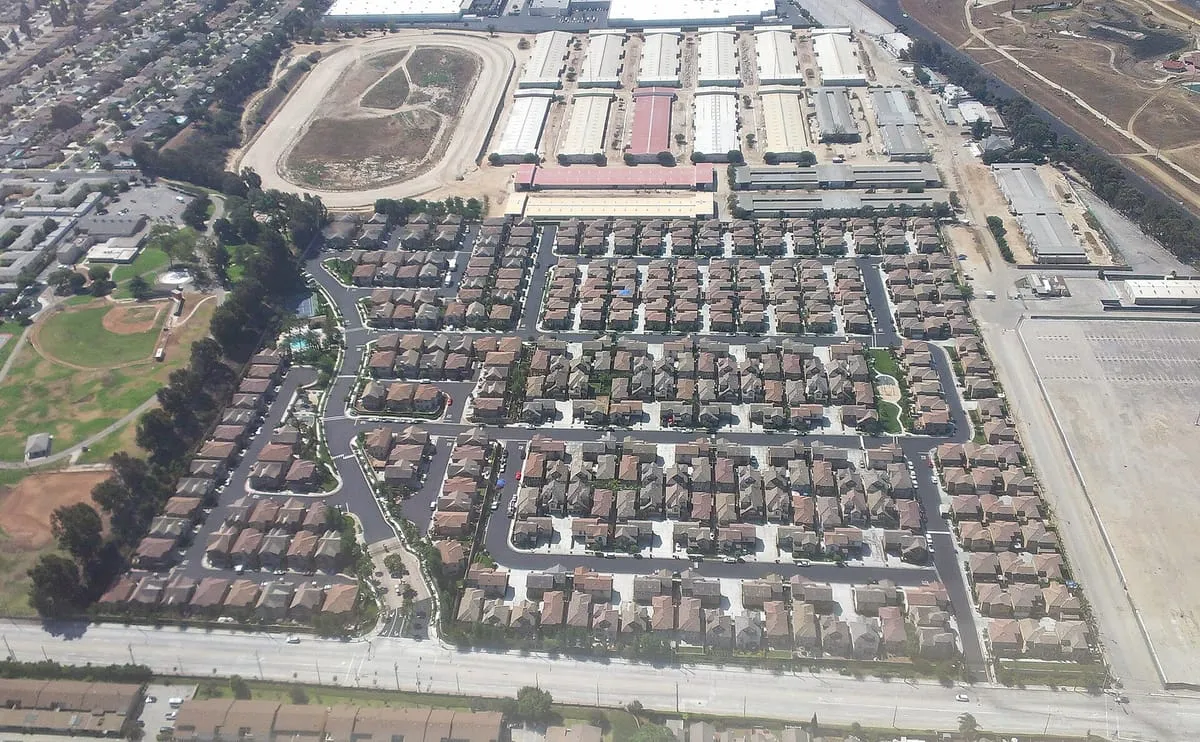 Aerial view of a tract housing neighborhood with rows of similar roofs