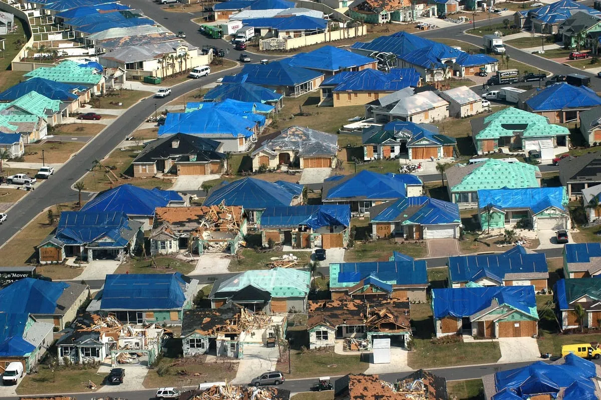 Aerial view of a Florida neighborhood with blue tarps and new roofing after tornadoes
